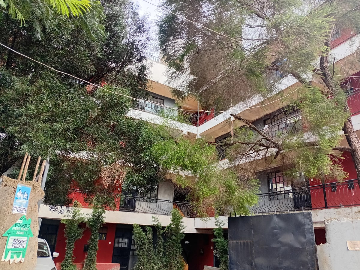 Multi-story residential building with lush greenery and balconies
