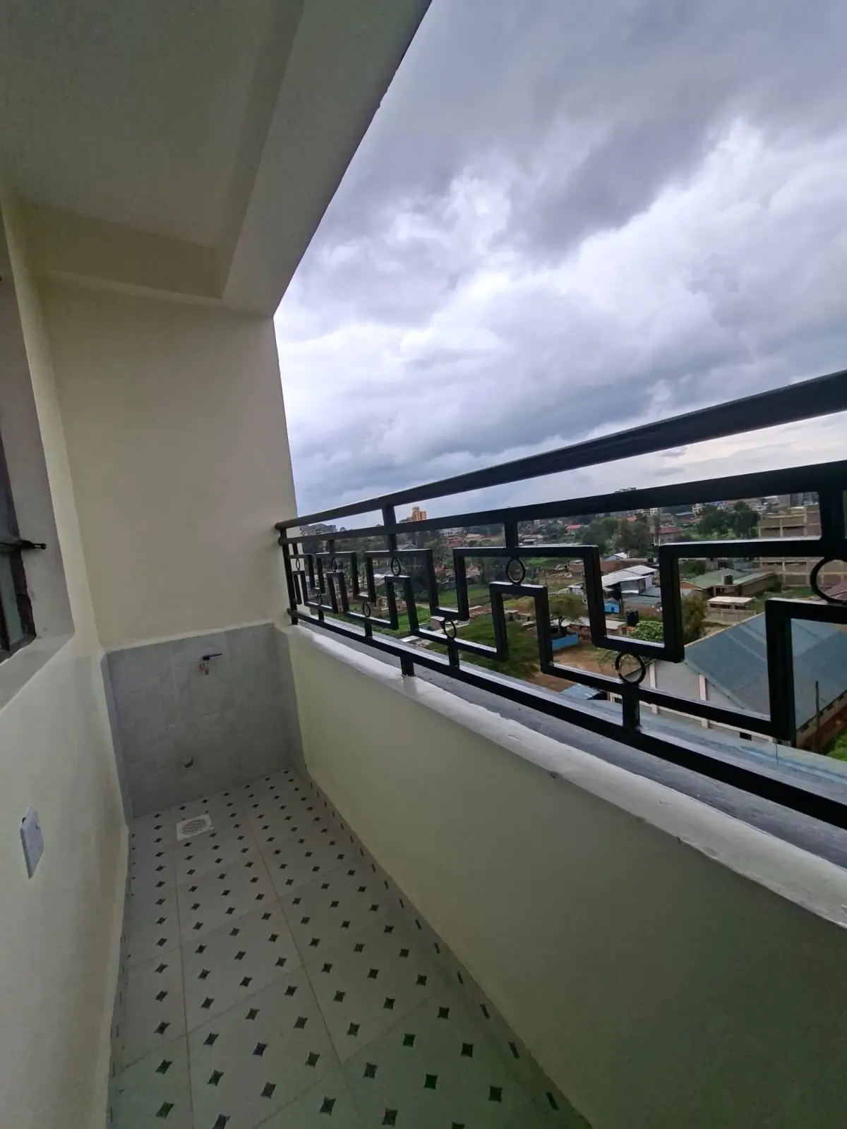 High-rise balcony with cityscape view and cloudy sky