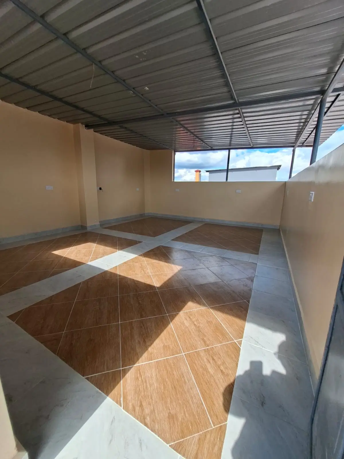 Empty living space with geometric tile flooring and natural light.