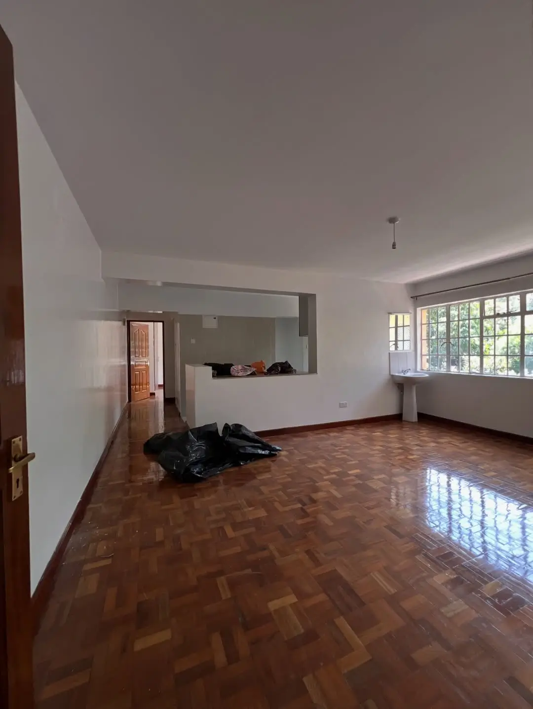 Spacious open-plan living area with herringbone wood flooring