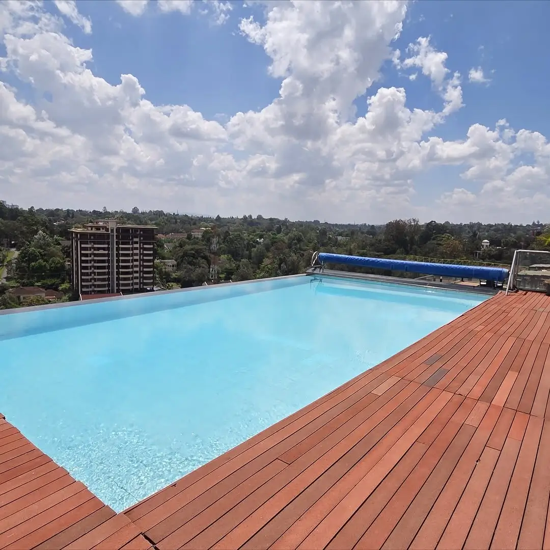 Rooftop swimming pool with wooden deck and city views