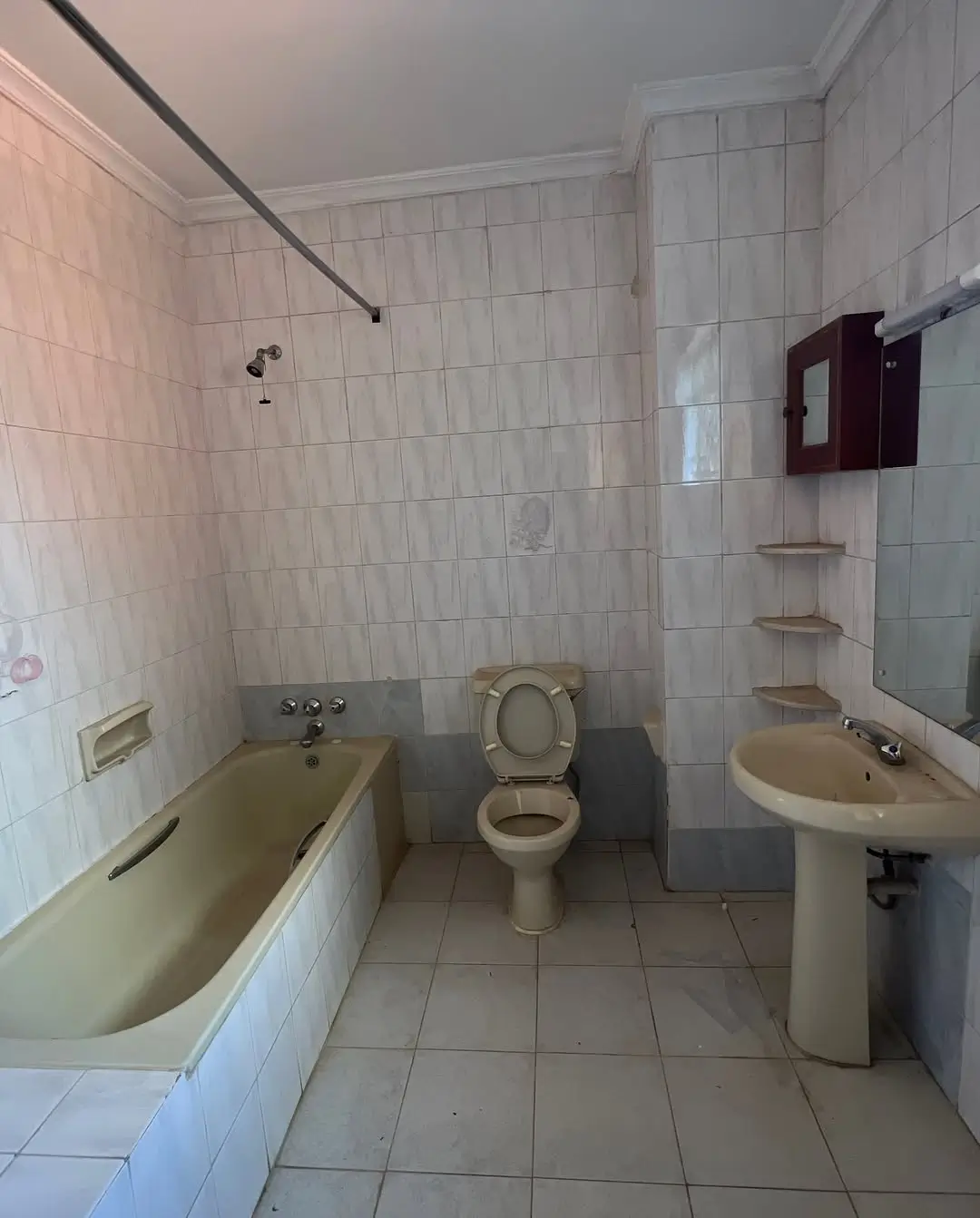 Spacious bathroom with bathtub, toilet, and dual sinks