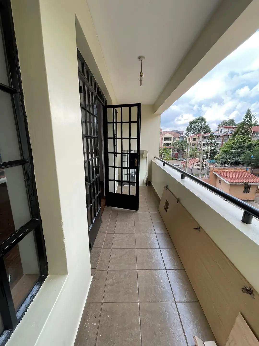 Long covered balcony with city view and security door