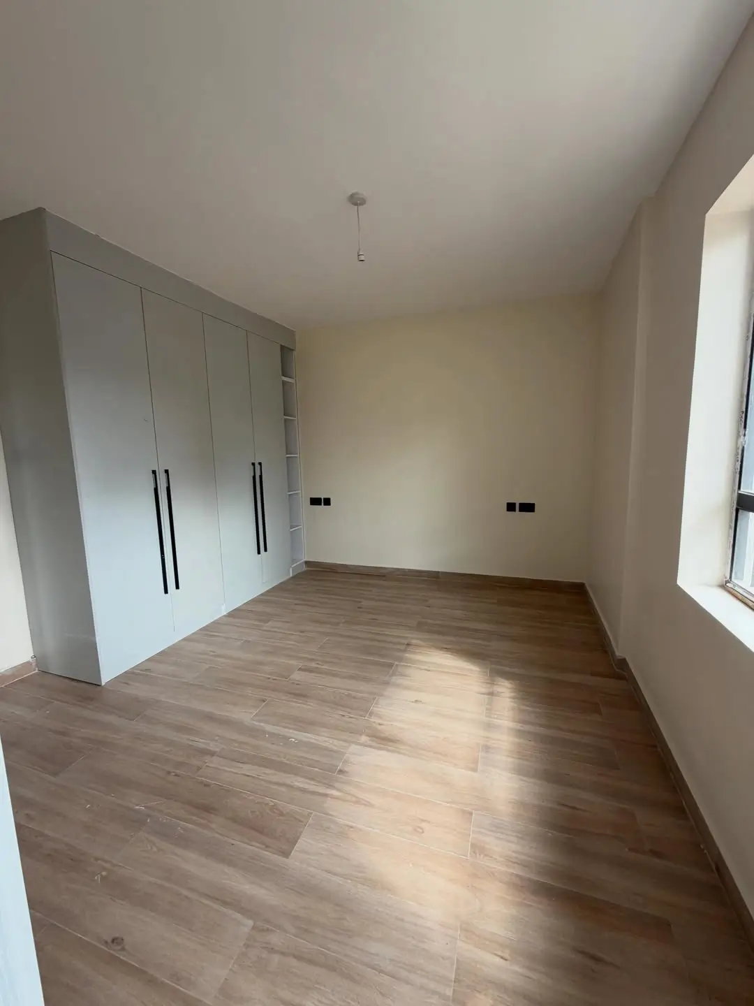 Spacious bedroom with built-in wardrobe and wooden flooring