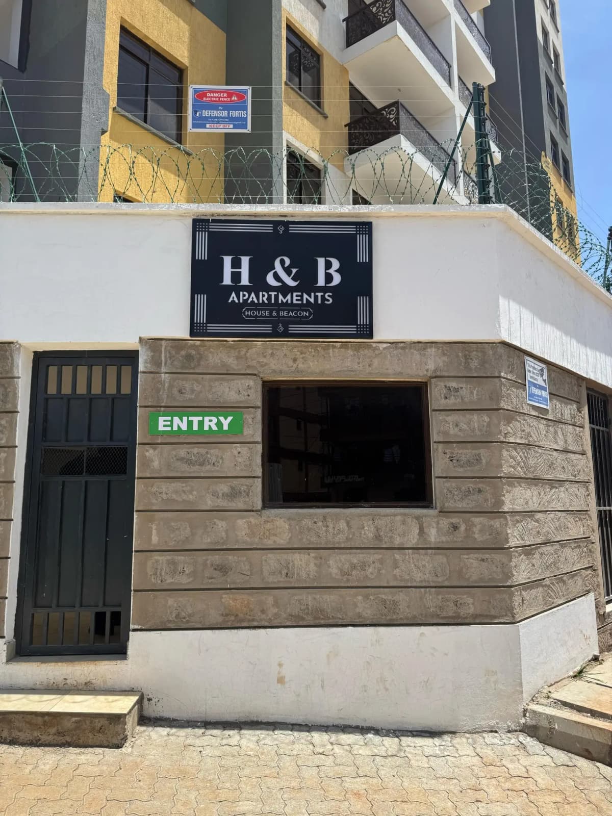 Building entrance with H&B Apartments signage and entry gate