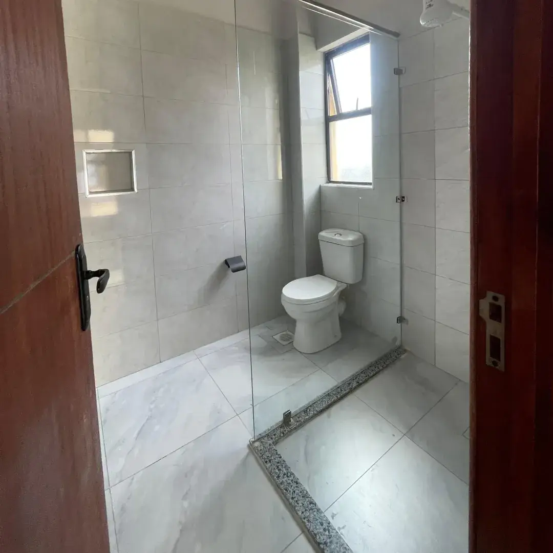 Modern bathroom with toilet, shower cubicle, natural light