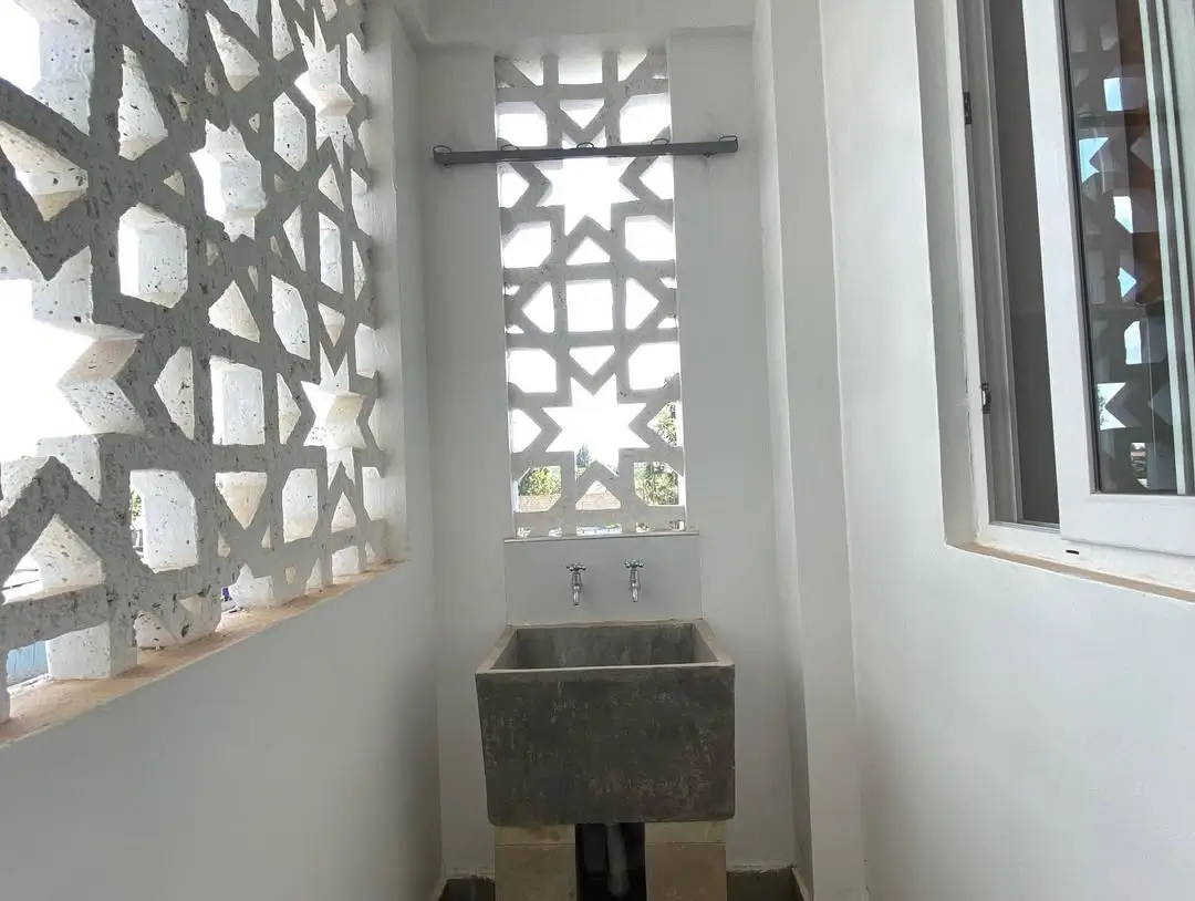 Minimalist bathroom with geometric window and stone sink