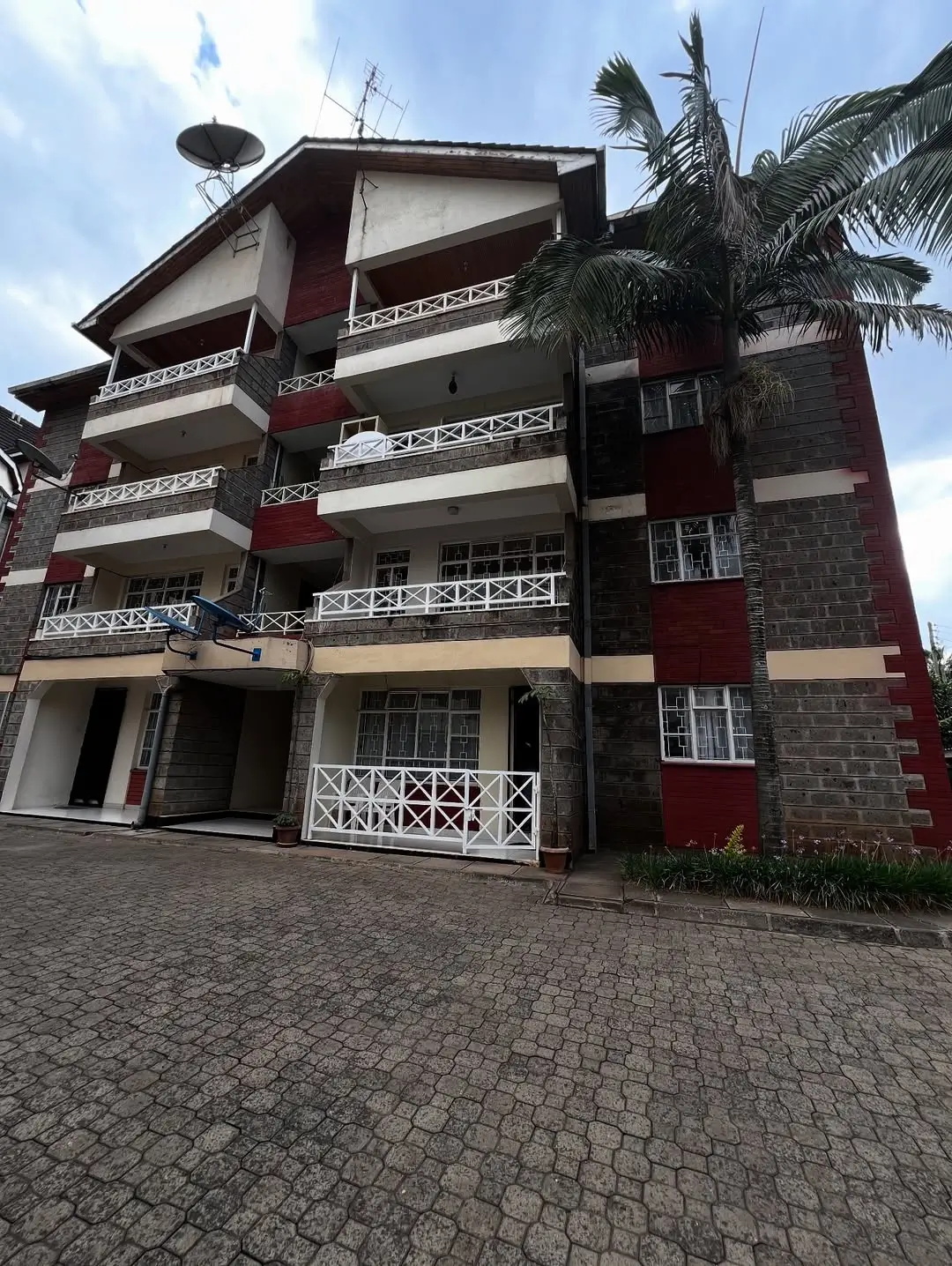Multi-story residential building facade with balconies and driveway