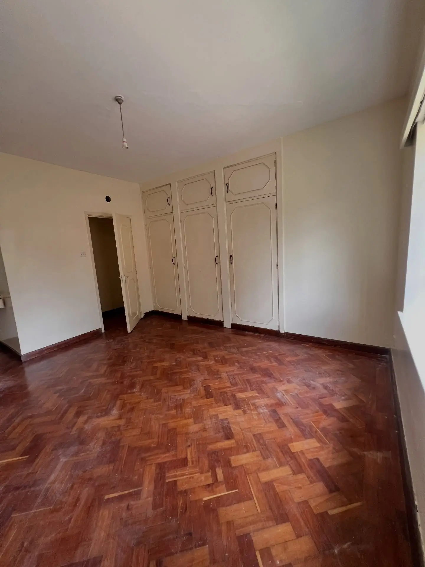 Spacious bedroom with built-in wardrobes and parquet flooring