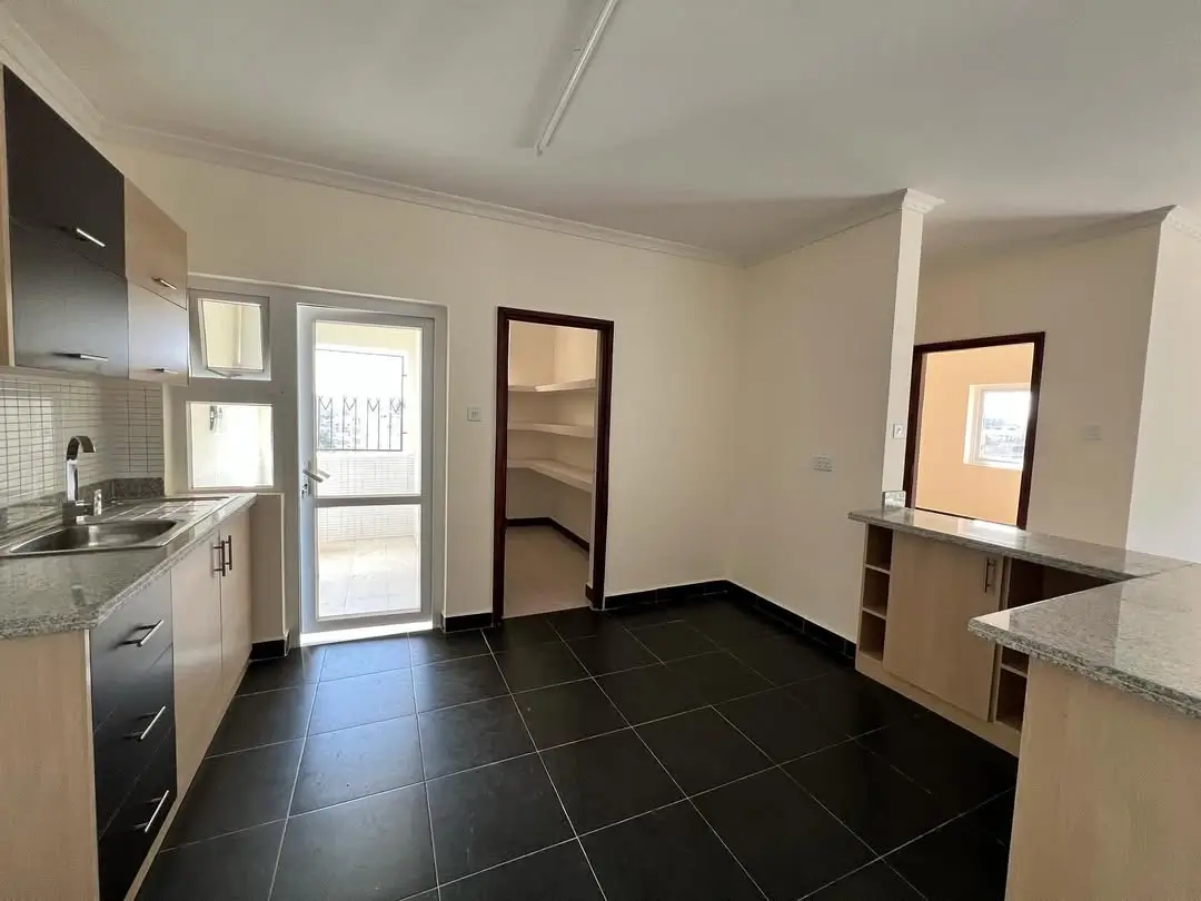 Open-plan kitchen with black tiled floor and dining counter