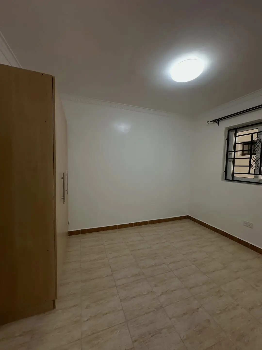 Unfurnished bedroom with wooden door and small window