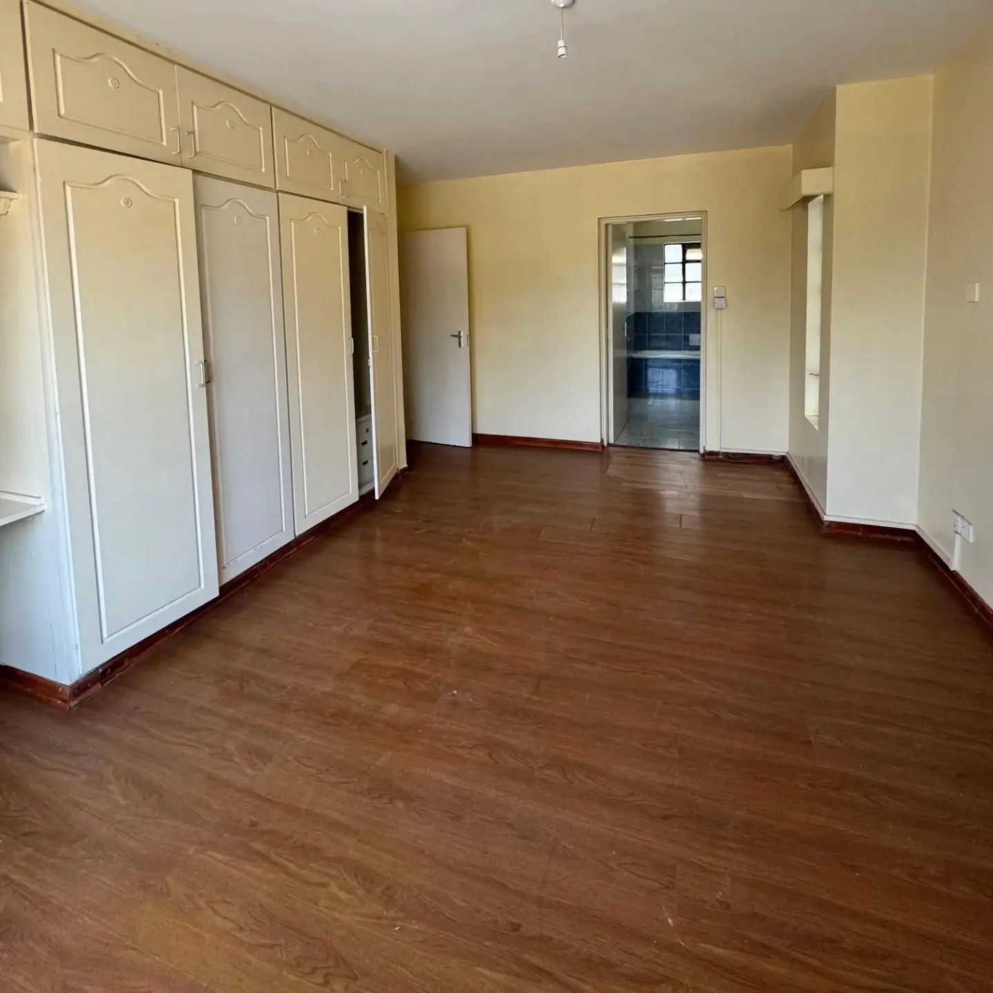 Spacious bedroom with built-in wardrobes and wooden flooring