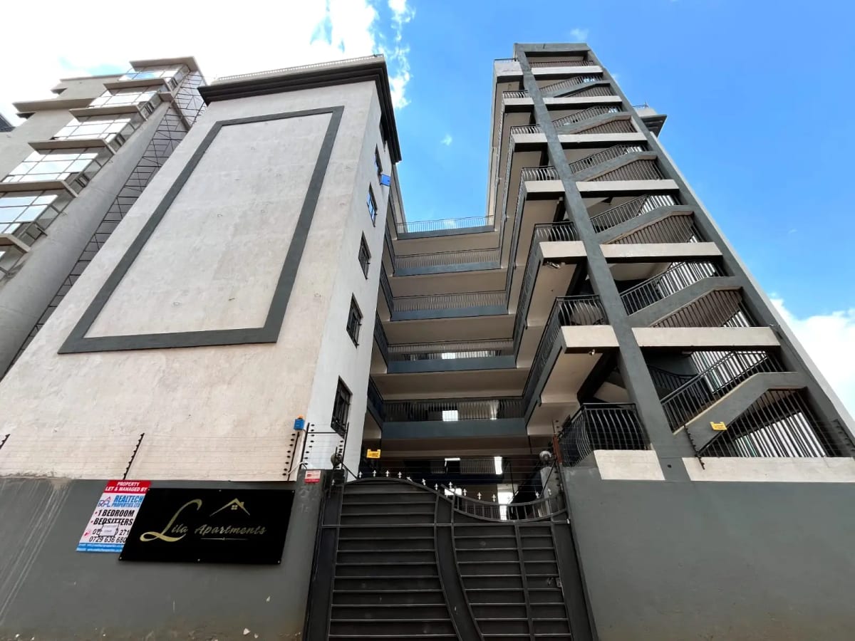 Modern apartment building facade with entrance gate and stairs