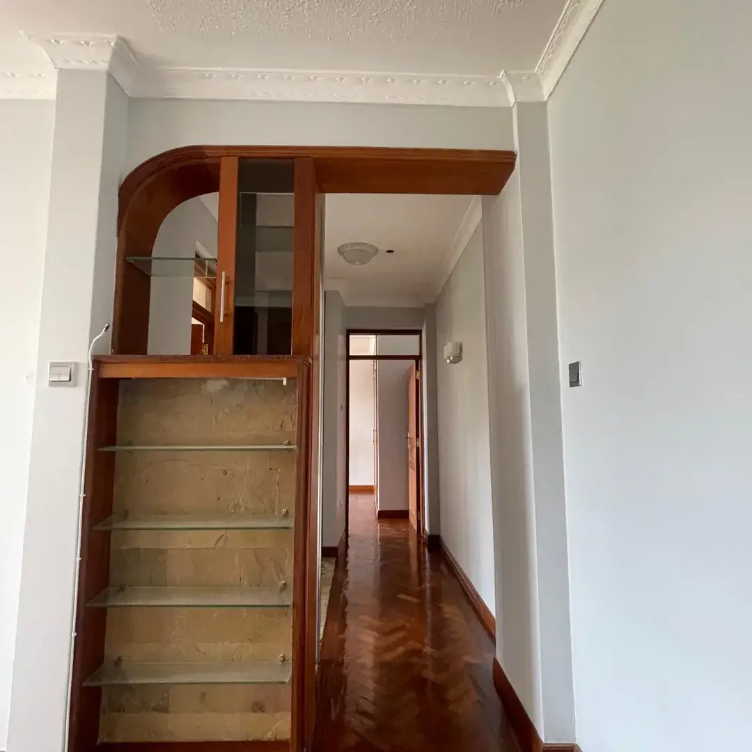 Building corridor with wooden staircase and white walls