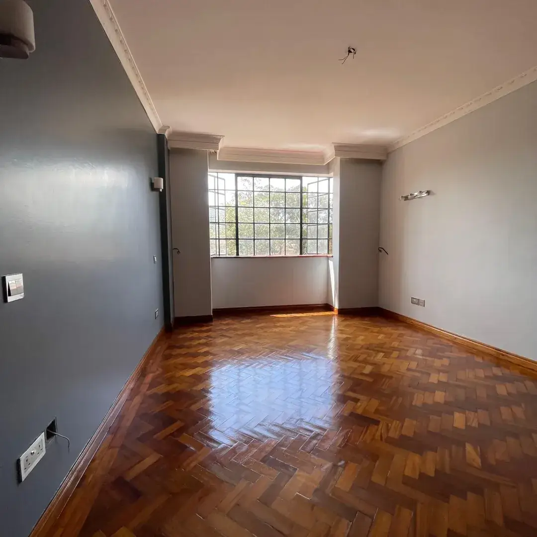 Spacious living room with herringbone wood flooring and natural light