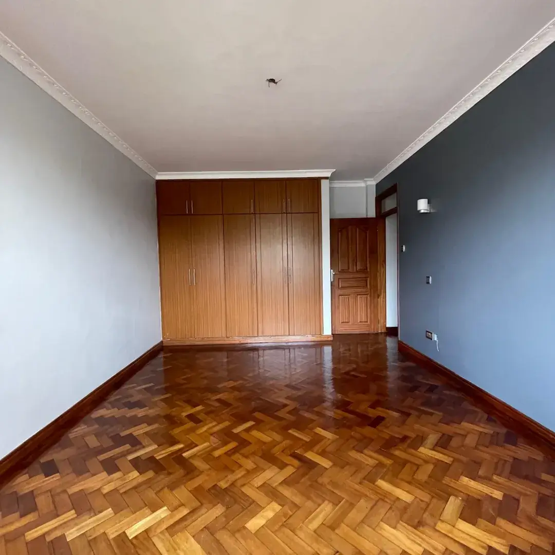 Spacious bedroom with wooden wardrobe and herringbone flooring