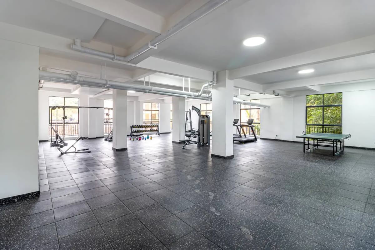 Spacious gym with cardio equipment, weight machines, natural light