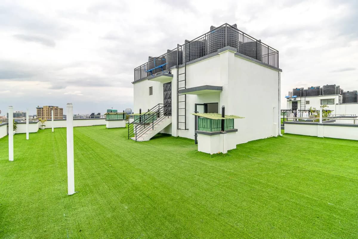 Modern white building with rooftop terrace on manicured lawn