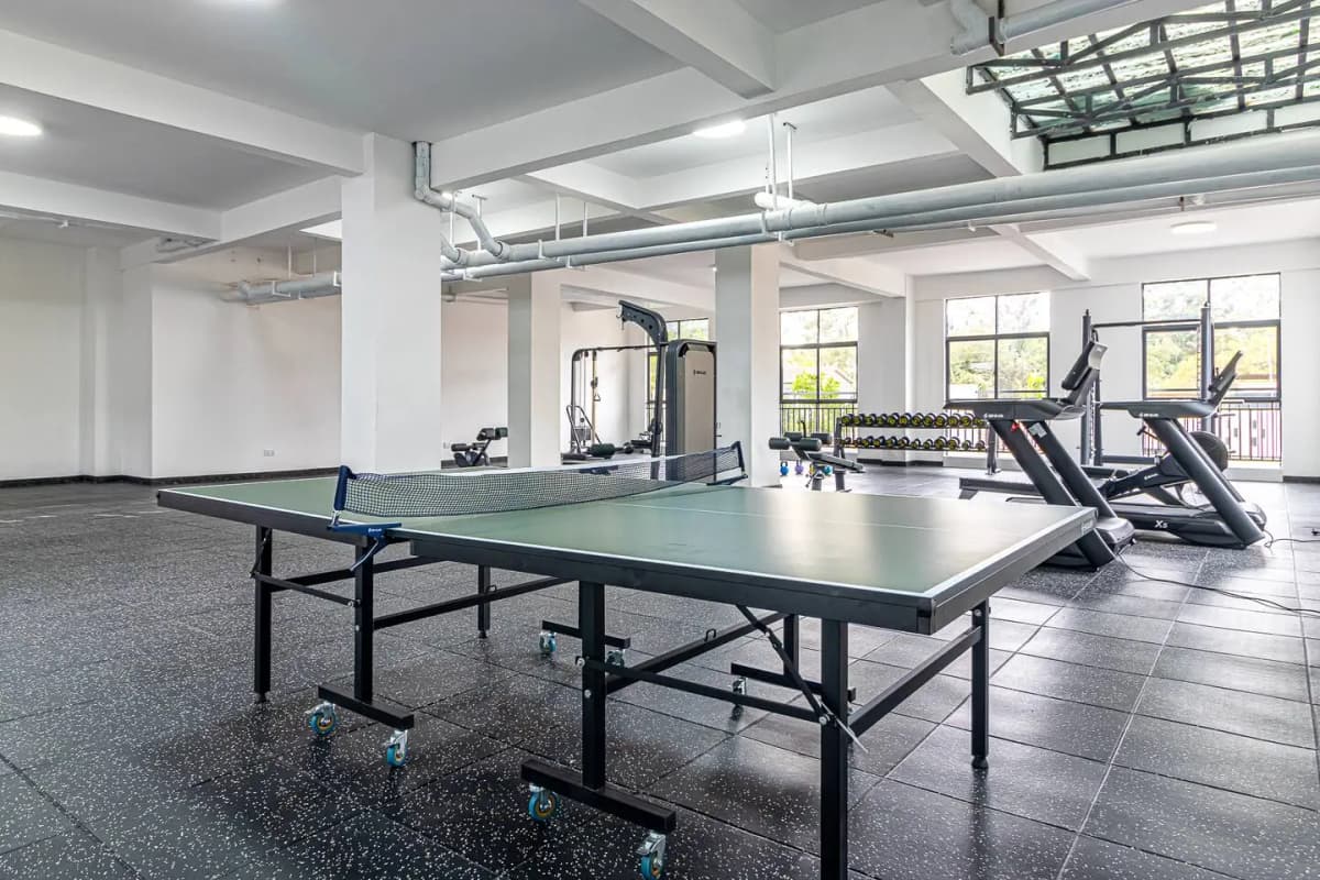 Spacious gym with ping pong table and cardio equipment