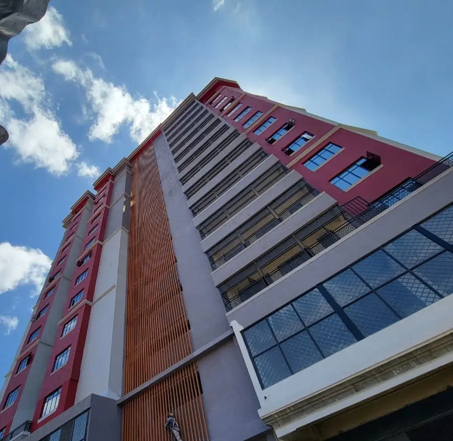 Modern multi-story residential building facade with red accent panels
