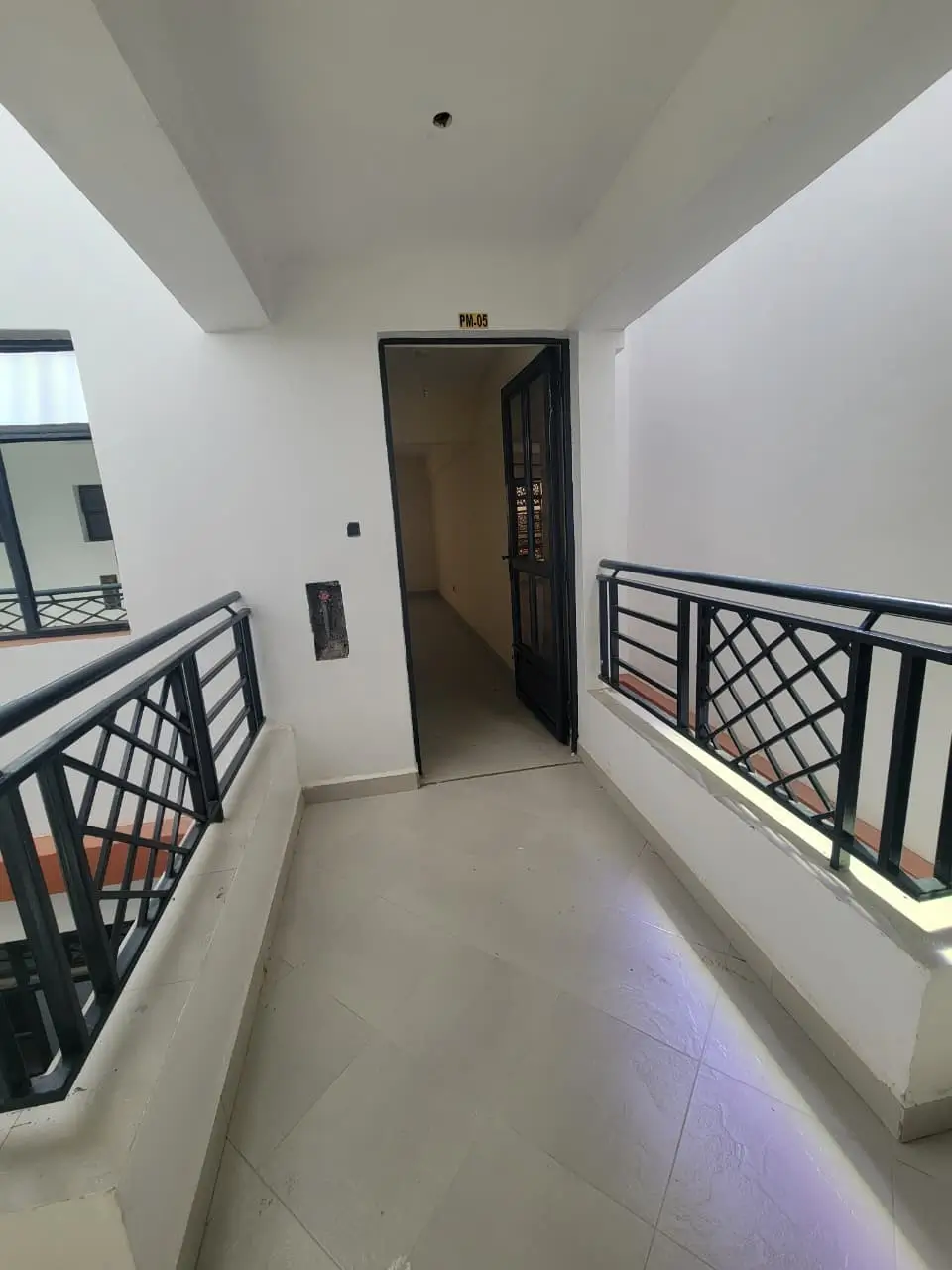 Building corridor with black railings and lift entrance