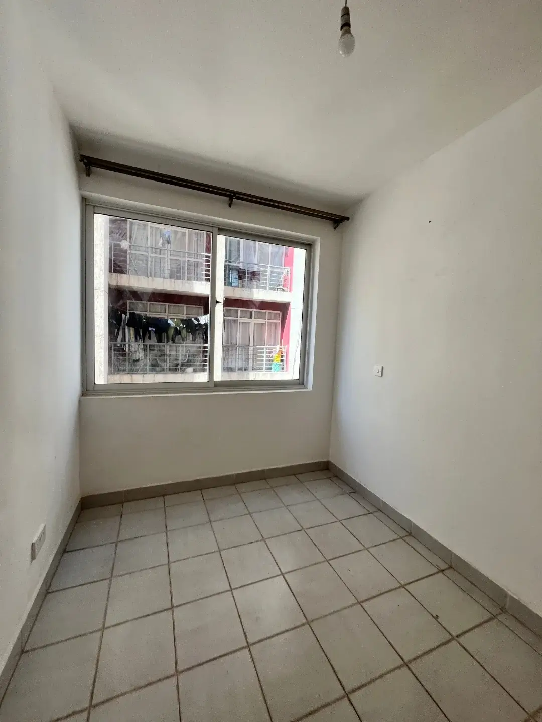 Compact bedroom with tiled floor and window view