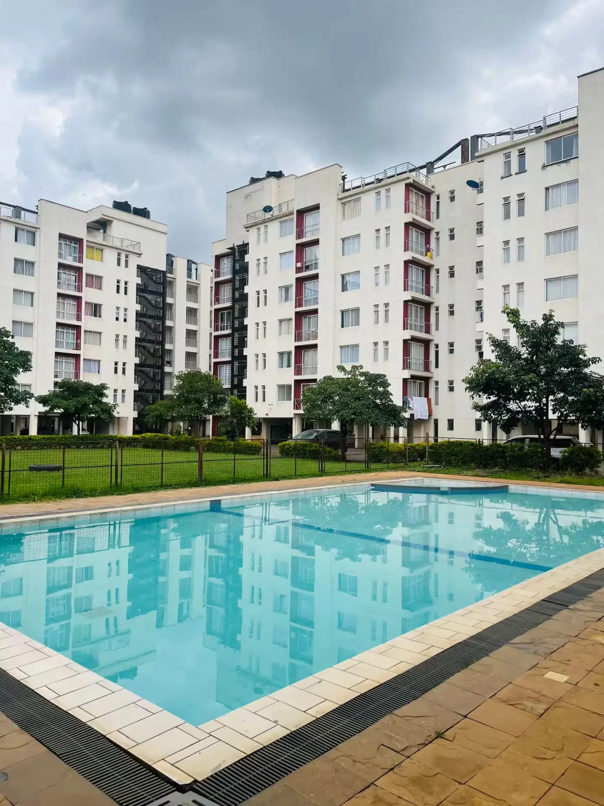 Rectangular swimming pool with modern apartment complex backdrop