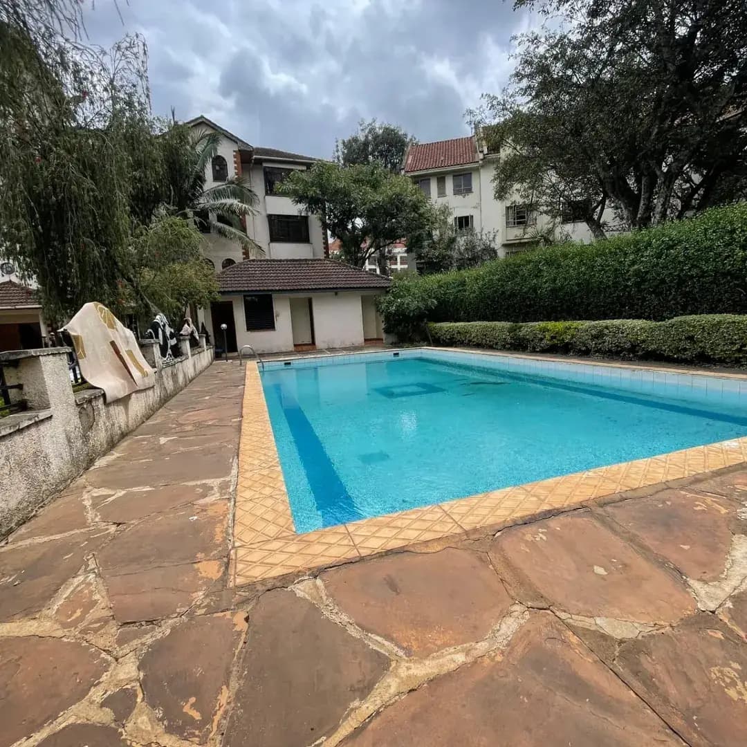 Large rectangular swimming pool with stone deck and manicured grounds