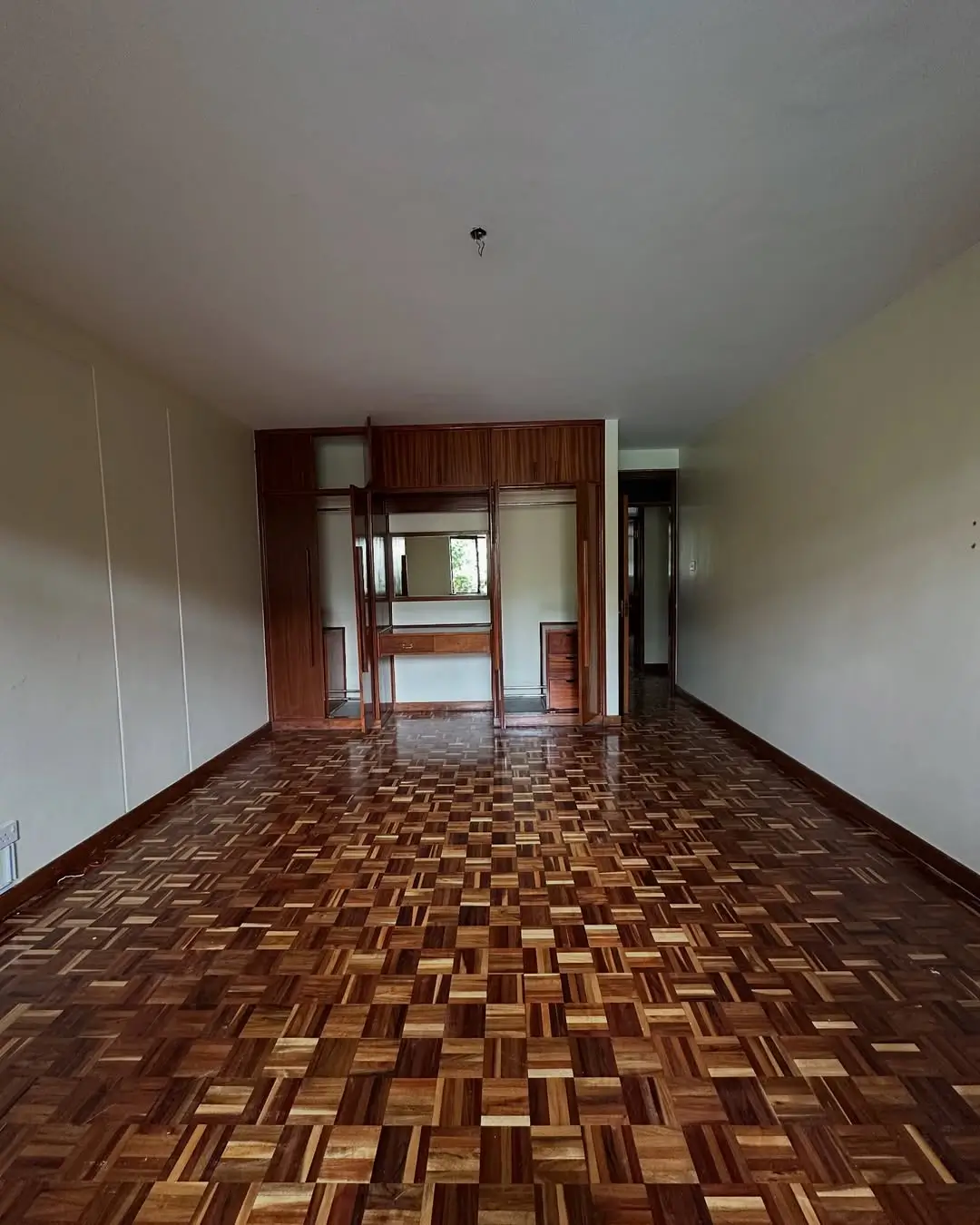 Spacious living room with parquet flooring and built-in wardrobe
