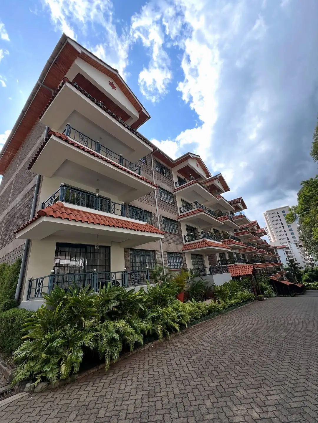Multi-story residential building with red tile roofing and balconies