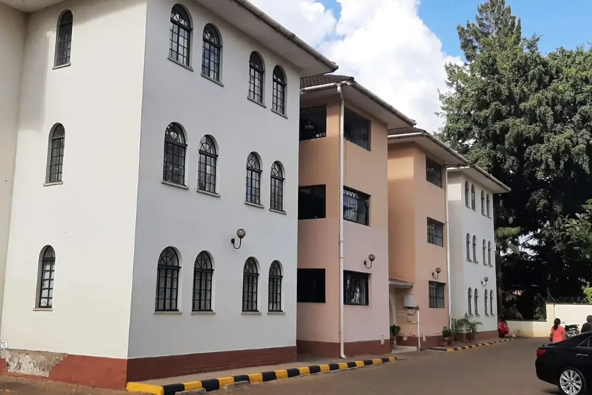 Multi-story residential building facade with manicured compound grounds.