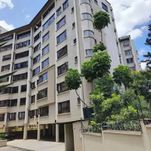 Multi-story residential building facade with green landscaping.