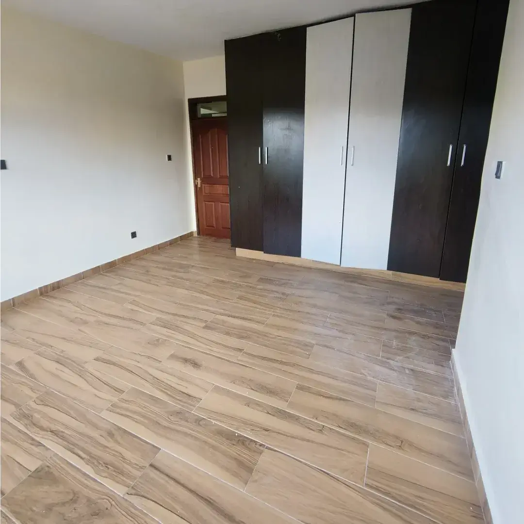 Spacious bedroom with built-in wardrobes and wooden flooring