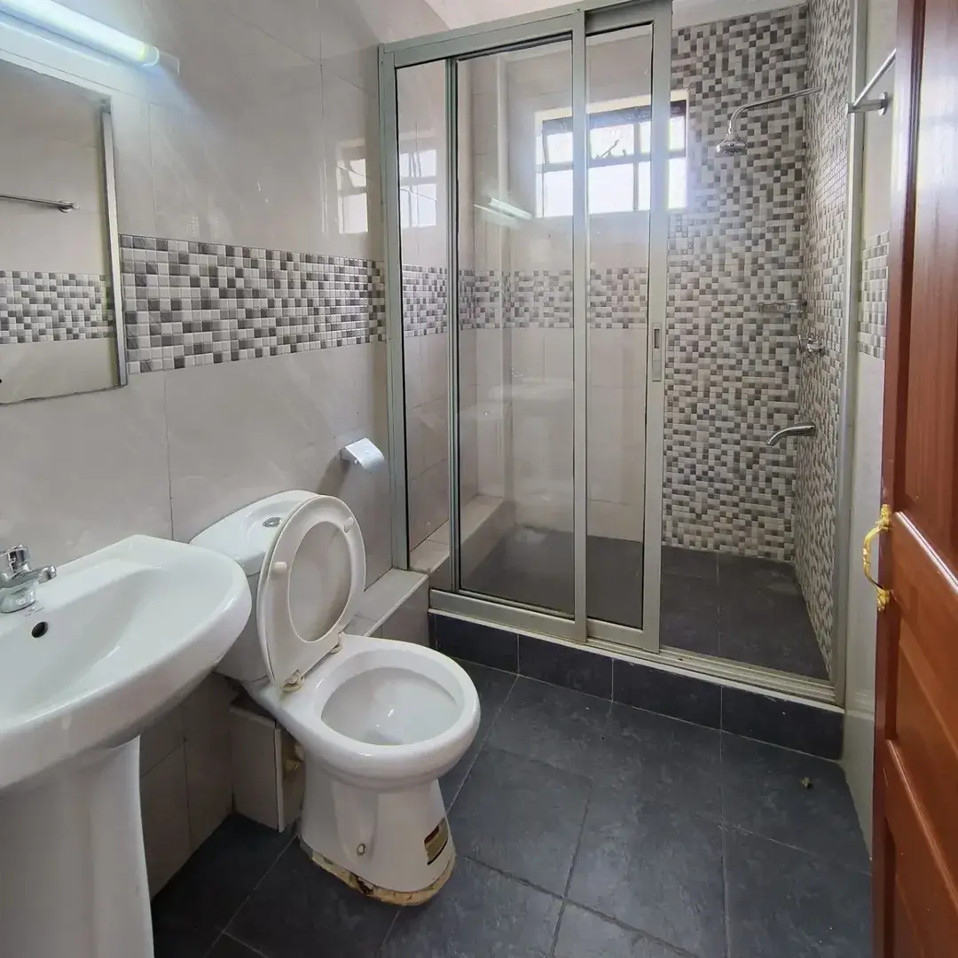 Bathroom with toilet, sink, and glass shower enclosure