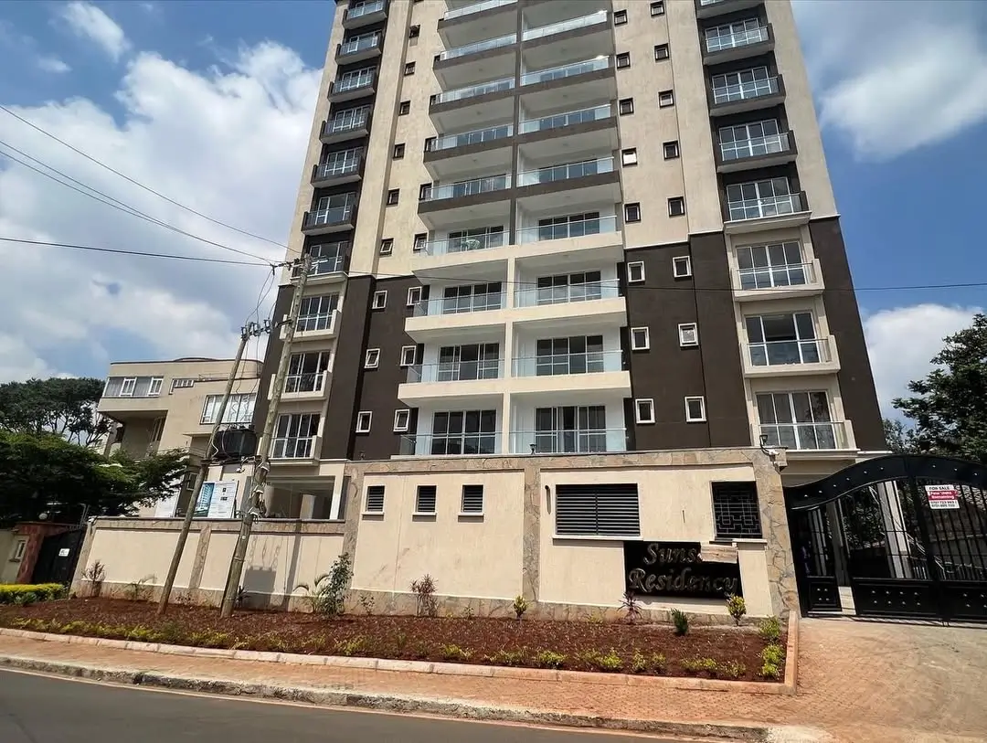 Multi-story residential building with gate and landscaped compound